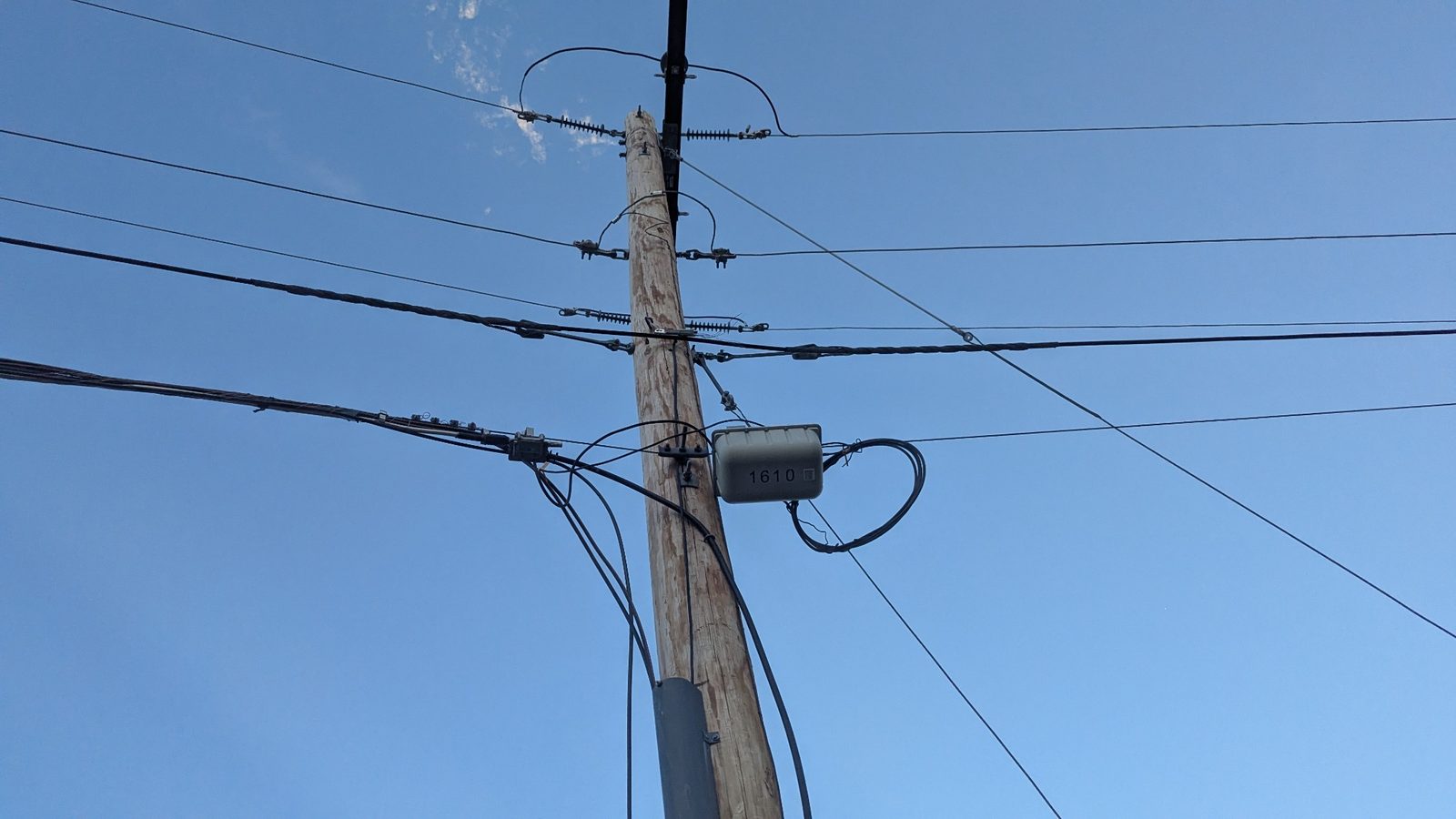 Overhead lines branch through the neighborhood from a pole-mounted enclosure.