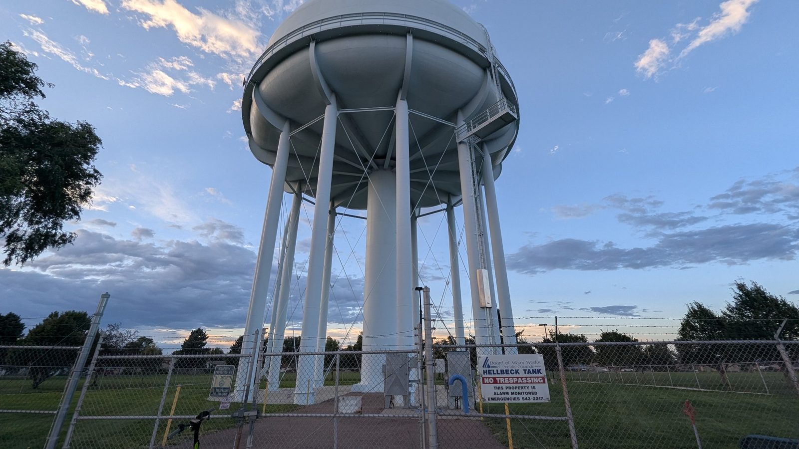 The water tower stands over its fenced equipment yard.