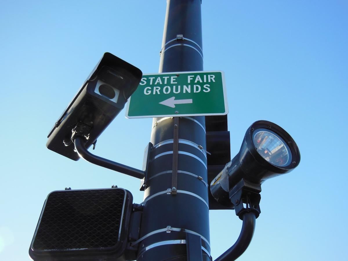 Box camera and floodlight under a State Fair Grounds sign
