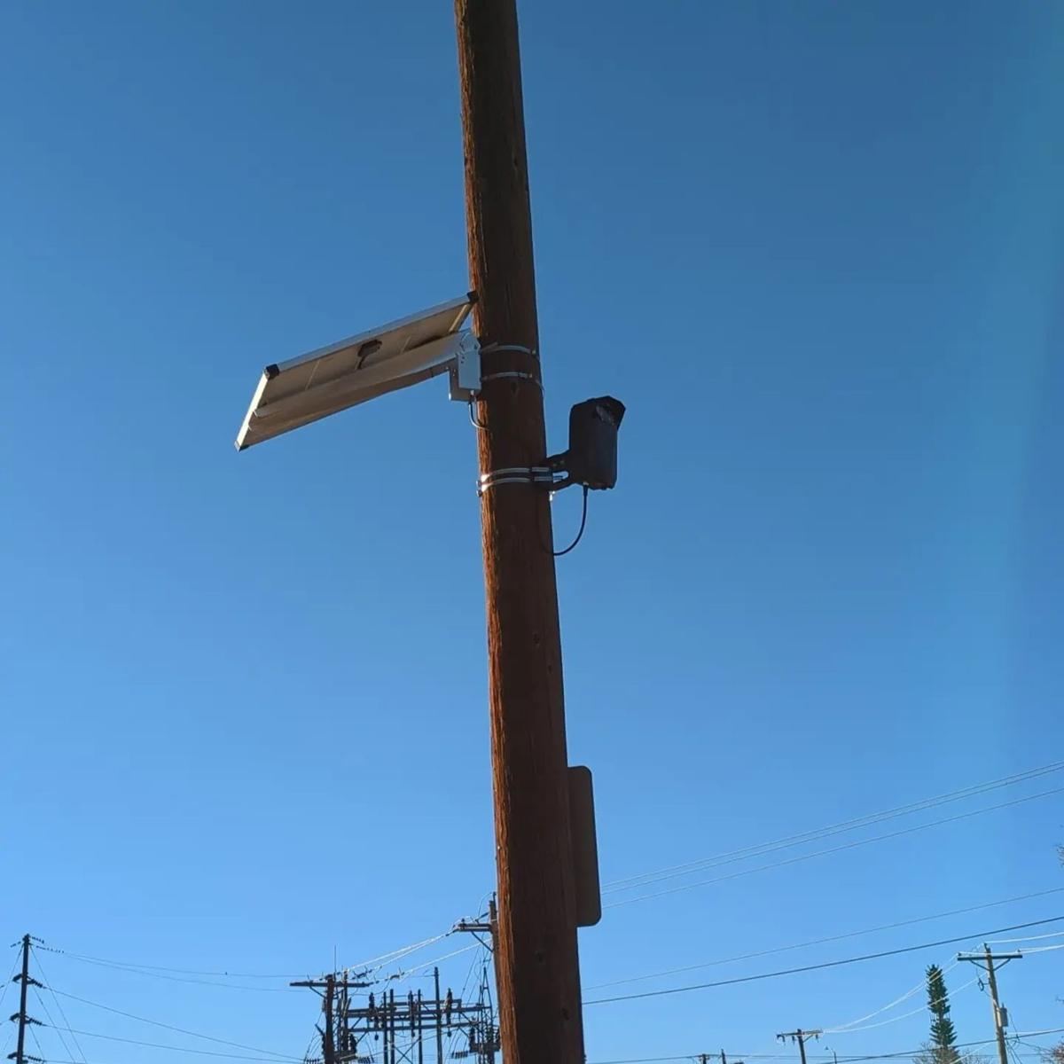 Camera and angled solar panel on a wooden pole