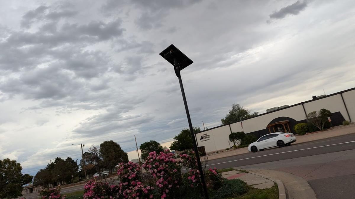 Solar camera pole beside a parking lot drive