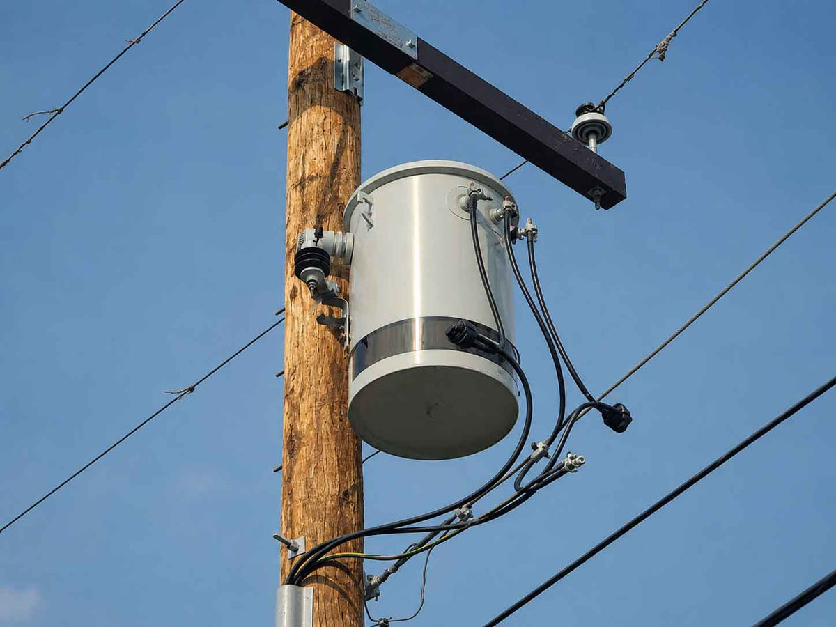 Manufacturer photograph of a transformer-shaped covert camera enclosure with a smoked-black band around its lower section