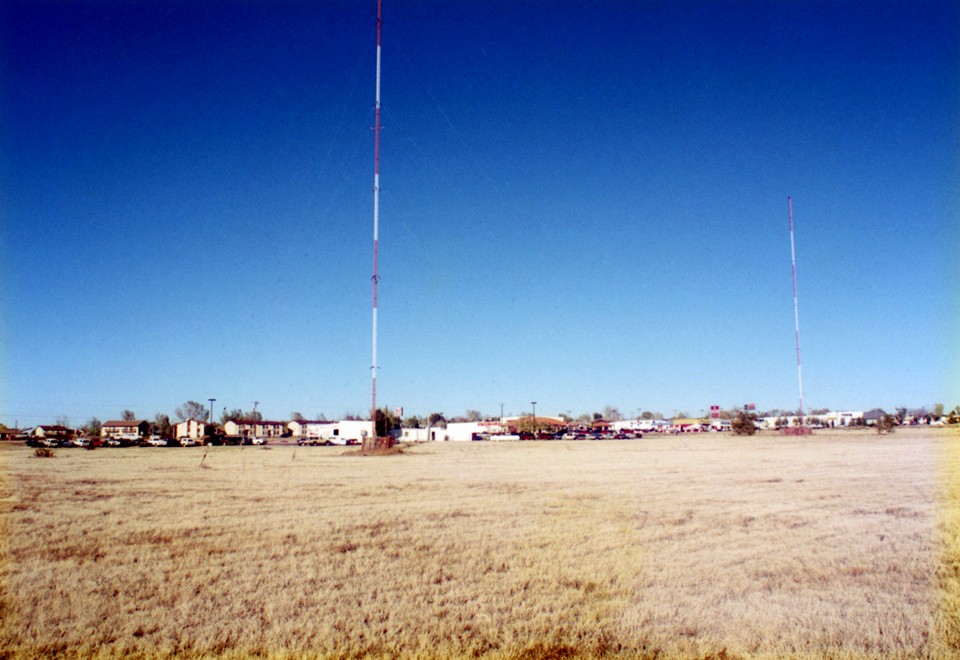Original family photograph showing Hwy 50 Autoplex between the two red-and-white AM towers in the 1990s.